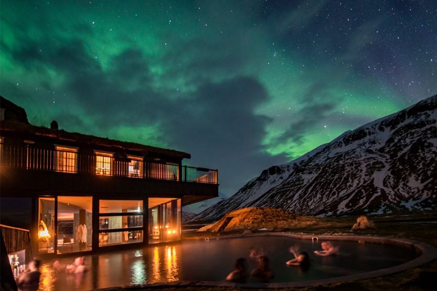 Outdoor heated pool at night at Deplar Farm Lodge with the Northern Lights in the sky.